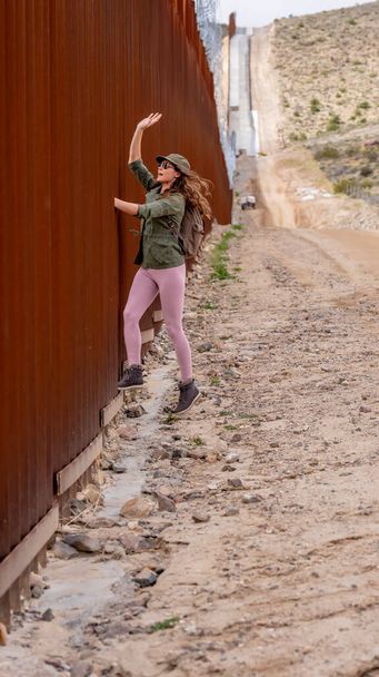 Un migrant désespéré traverse le mur frontalier de Jacumba, cherchant à entrer illégalement aux États-Unis, soulignant les défis de l'immigration en cours - Photo, image