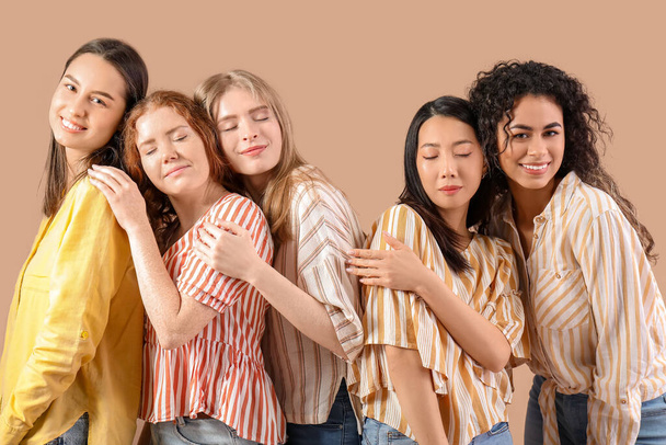 Beautiful young women on beige background. Women history month - Photo, Image