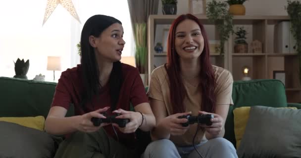 Dos jóvenes mujeres caucásicas amigas o hermanas juegan videojuego de consola - Metraje, vídeo