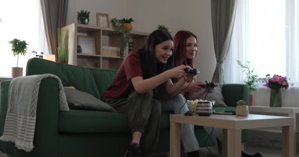 Dos jóvenes mujeres caucásicas amigas o hermanas juegan videojuego de consola - Metraje, vídeo