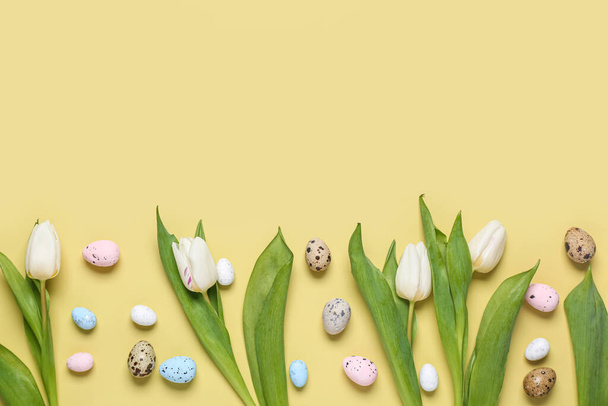Easter eggs with tulip flowers on yellow background - Photo, Image
