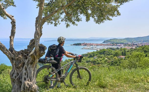 nice active senior woman on a mountain bike tour at the Slovenian Mediterranen cost above Izola - Photo, Image