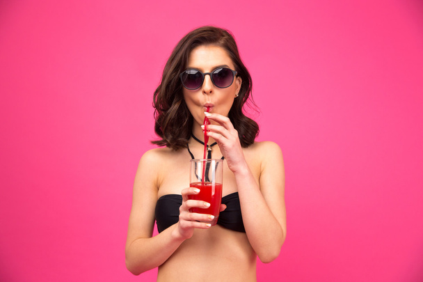 Giovane donna in costume da bagno in possesso di un bicchiere di succo
 - Foto, immagini