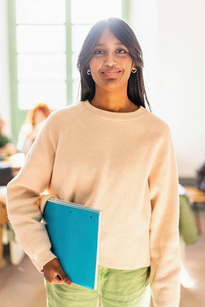 Magabiztos fiatal indiai nő oktatási környezetben kezében egy notebook - Akadémiai teljesítmény és sokszínűség koncepció - Fotó, kép