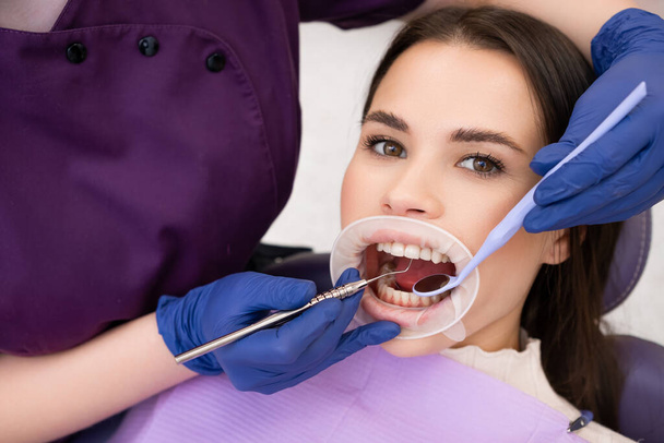 Portrait de femme brune a le contrôle des dents dans la clinique denstist.  - Photo, image