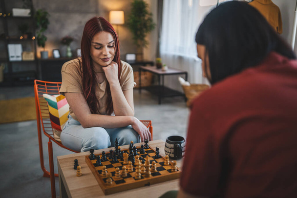 dvě ženy mladé ženy sestry přátelé hrát šachovnici hru doma - Fotografie, Obrázek