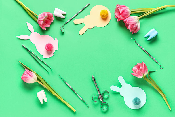 Plastik dişli diş aletlerinden yapılmış çerçeve, yeşil arka planda Paskalya tavşanları ve lalelerden - Fotoğraf, Görsel