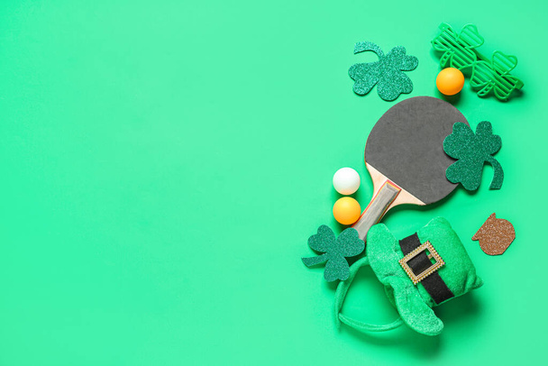Raquette de ping-pong, balles, trèfles et chapeau de lutin sur fond vert. Célébration de la Saint Patrick - Photo, image