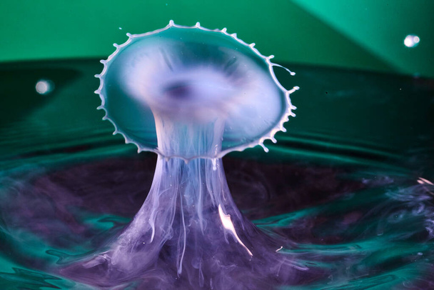 Fotografía de gota de agua de alta velocidad que captura un chapoteo vibrante contra un fondo verde, mostrando el arte en movimiento fluido, Fort Wayne, Indiana, 2017 - Foto, imagen