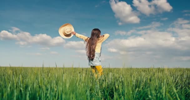 Farmer nő kaukázusi bolgár lány szalma kalap boldog ugrás zöld búza mező vidéken egy napsütéses napon 4K videó - Felvétel, videó