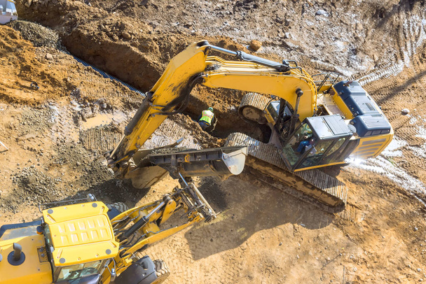 En esta gran excavadora se está excavando en un sitio industrial que se está desarrollando un proyecto de infraestructura - Foto, Imagen