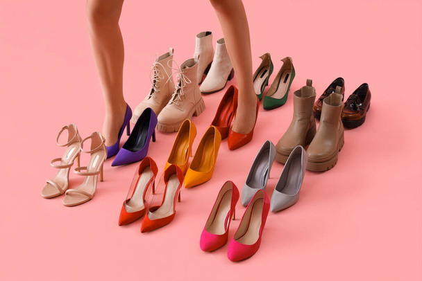 Γυναικεία πόδια με διαφορετικά ψηλοτάκουνα παπούτσια σε ροζ φόντο - Φωτογραφία, εικόνα