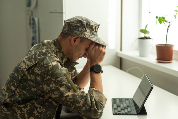 Un soldado angustiado cubriéndose la cara, posiblemente sufriendo de shock de concha o Trastorno de Estrés Post Traumático. Foto de alta calidad - Foto, imagen
