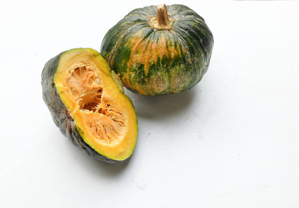 Куча свежей зеленой японской тыквы (Cucurbita moschata), Кабоча сквош, как в мяч и порез, показывая желтую плоть изолированы на белом backdrop.Healthy пищевой овощ, фрукты, и пищевой бизнес - Фото, изображение