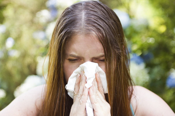 Girl sneezing into a tissue - Photo, Image