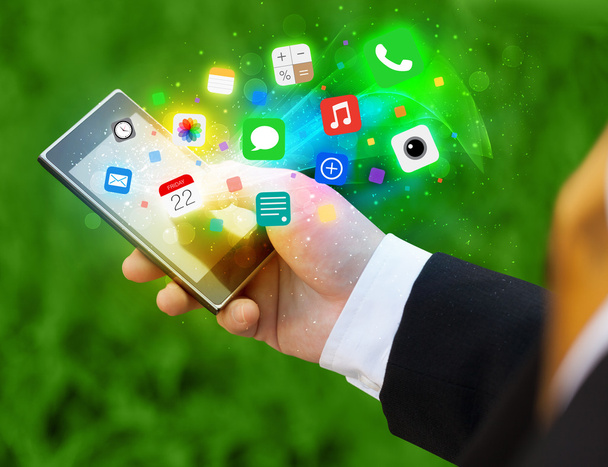 Mão segurando smartphone com ícones de aplicativos coloridos - Foto, Imagem