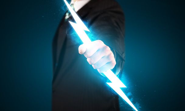 Business man holding glowing lightning bolt in his hands - Foto, immagini