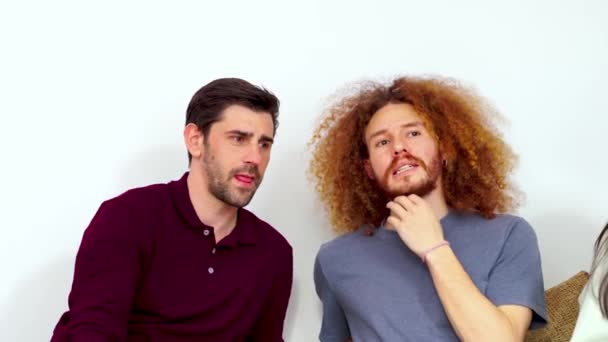 Δύο άνδρες που εμπλέκονται σε μια συζήτηση, ένας με εντυπωσιακά σγουρά μαλλιά, σε ένα μινιμαλιστικό λευκό δωμάτιο.  - Πλάνα, βίντεο