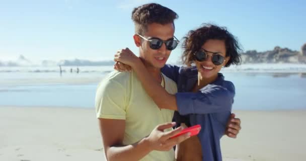 Pari, selfie ja suudella rannalla sosiaalisen median lomalla yhteyden, seikkailu tai matkustaminen. Mies, nainen ja rentoutua merellä onnellinen syleillä meressä rakastava sitoutuminen, kesällä tai viikonloppuna. - Materiaali, video