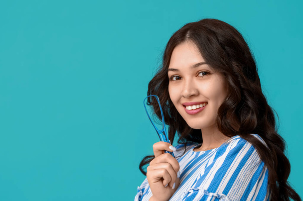 Boldog fiatal ázsiai nő nyelvvakaró kék háttér - Fotó, kép