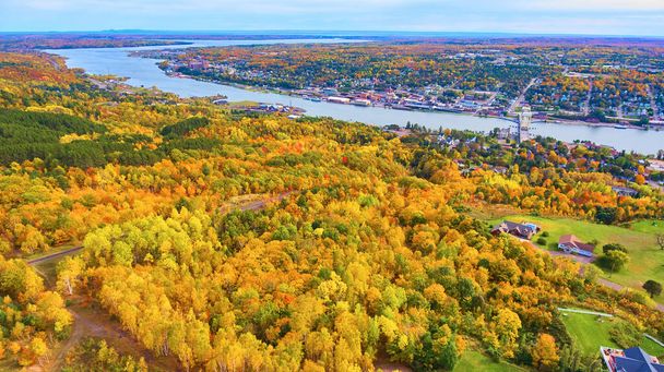 Luftaufnahme von Houghton, Michigan: Lebendiges Herbstlaub trifft städtische Umgebung am Fluss - Foto, Bild