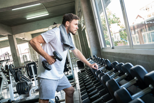 Fešák atletický muži cvičení s Dumnbell ve fitness tělocvičně zdravý životní styl - Fotografie, Obrázek