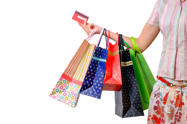 Vrouw met kleurrijke boodschappentassen en credit card geïsoleerd op wit - Foto, afbeelding