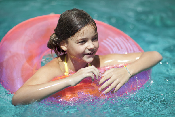 meisje kind in blauwe water van het zwembad - Foto, afbeelding