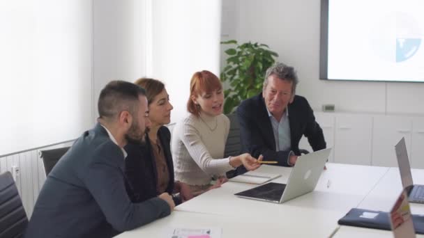 Επαγγελματική ομάδα που εξετάζει τα στοιχεία για το lap-top στο σύγχρονο γραφείο - Πλάνα, βίντεο