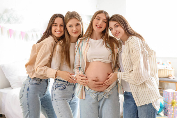Mladá těhotná žena se svými přáteli objímání na baby párty v ložnici - Fotografie, Obrázek
