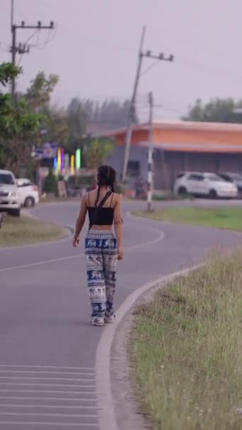 Κορίτσι με δύο κοτσίδες περπατά κατά μήκος της χώρας δρόμο - FHD Κάθετη βίντεο - Πλάνα, βίντεο