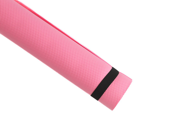Розовый коврик для йоги на белом фоне. кроме фитнес-оборудования. - Фото, изображение