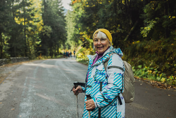 Turystyka, Dojrzałe kaukaskie starsza kobieta w przyrodzie do ćwiczeń, spacery wakacje i korzystających z gór. Podróż, emerytura i starszy mężczyzna i kobieta na spacer w lesie lub lesie na trekking - Zdjęcie, obraz