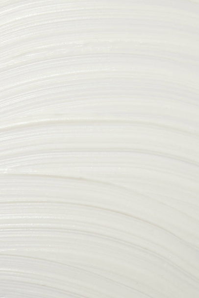 Crema cosmética blanca gruesa aplicada a la superficie. textura de la crema de primer plano. - Foto, Imagen