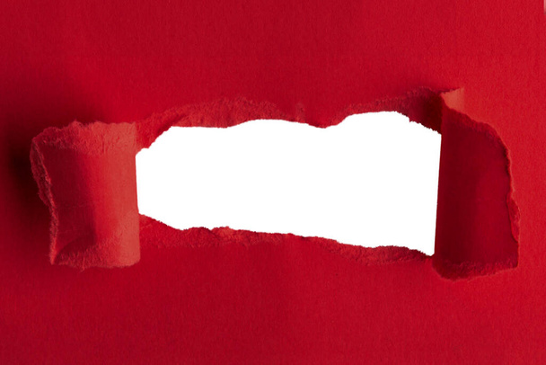 Красная толстая бумага, разорванная посередине с пустой дырой. И пустой фон позади - Фото, изображение