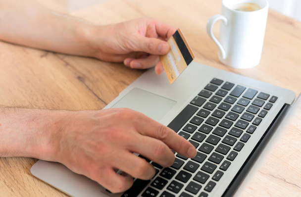 Hand mit Kreditkarte und Laptop. Online-Shopping-Konzept - Foto, Bild