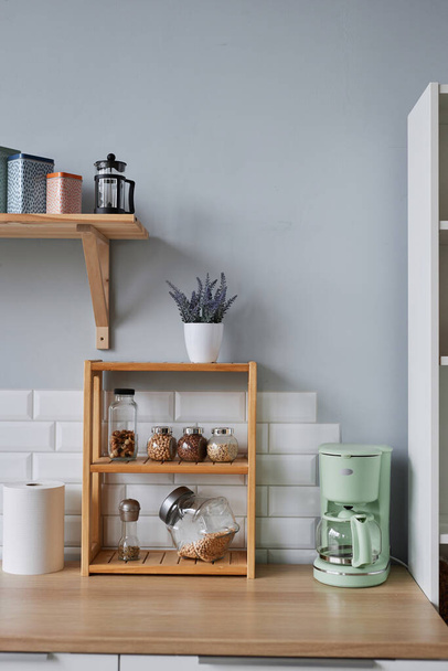 Vertikální pozadí obrazu kuchyňského designu, dřevěné police s kořením a bylinkami na kuchyňské lince vedle pastelových barevných spotřebičů - Fotografie, Obrázek
