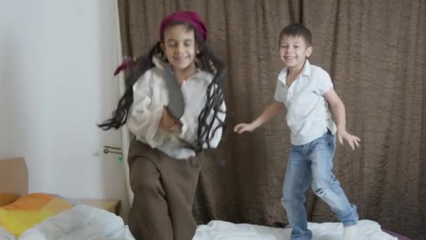 Милые мальчики, одетые в пиратские костюмы, прыгают на кровати. Высококачественные 4k кадры - Кадры, видео