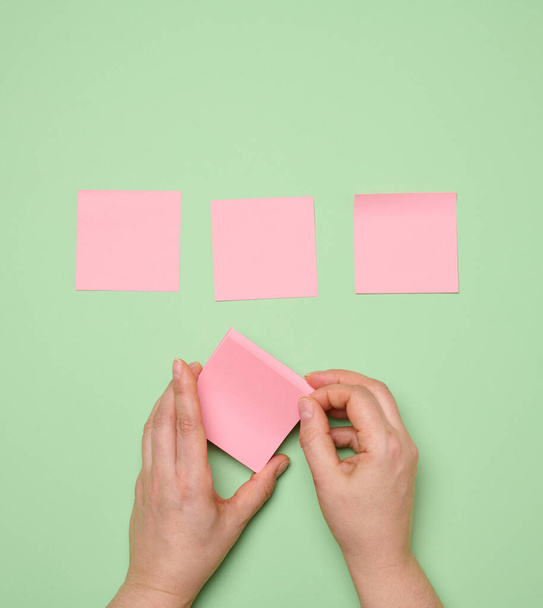 Colado adesivos de papel quadrado em branco rosa no fundo verde - Foto, Imagem