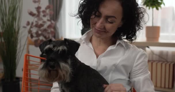 портрет дорослої білої жінки зрілої жінки з собакою вдома - Кадри, відео