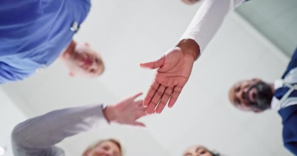People, nurse and hands together in teamwork, diversity or motivation below in collaboration or unity at hospital. Low angle of group or medical employees piling in healthcare or solidarity at clinic. - Filmati, video