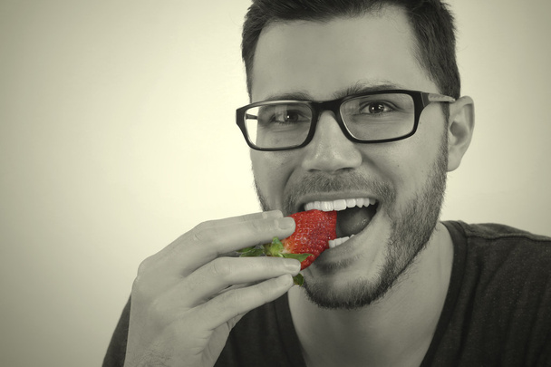 イチゴを食べて若い男 - 写真・画像