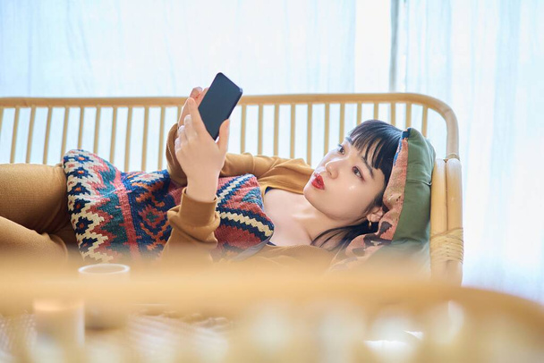 Jeune femme regardant smartphone tout en dormant - Photo, image