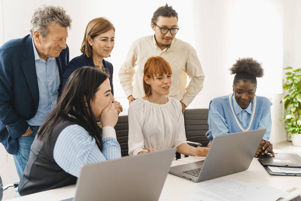 Une équipe diversifiée évalue un projet en ligne - Des employés engagés partagent leurs idées - Analyse collaborative du travail numérique. - Photo, image