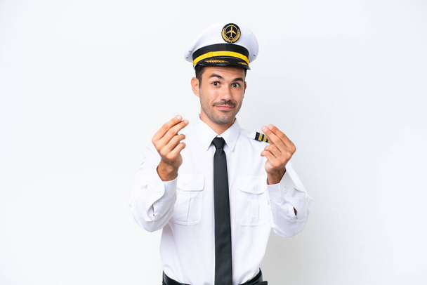 Pilote d'avion sur fond blanc isolé faisant geste d'argent - Photo, image