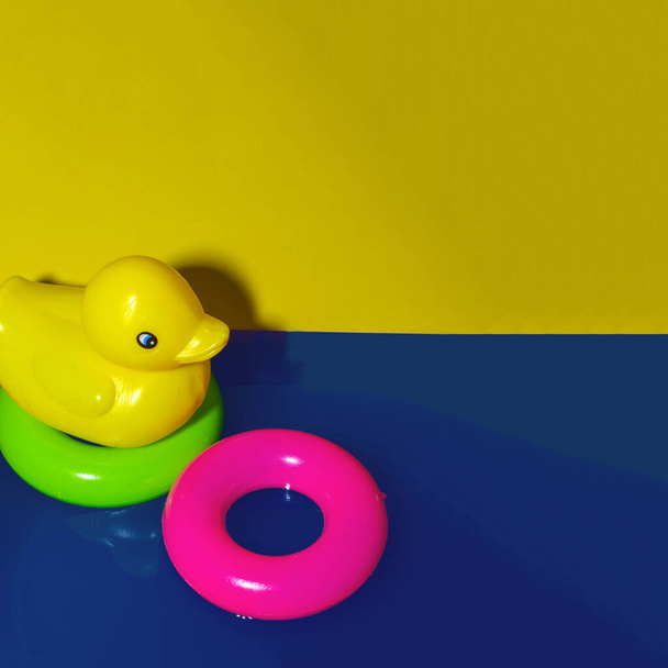 Yellow rubber duck and swimming tube on water. Creative summer concept.  - Photo, Image