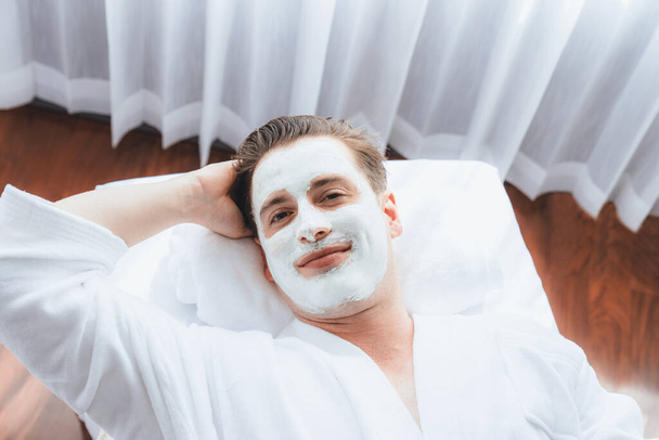 Nyugodt hangulatú spa szalon, férfi ügyfél kényezteti fiatalító luxus arckrém masszázs modern nappal. Arcbőr kezelés és szépségápolás koncepció. Csendes - Fotó, kép