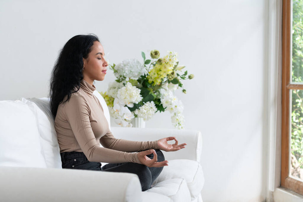 Jovem afro-americana praticar meditação consciente crucial em casa sala de estar para melhorar a força da saúde mental e pacífica bela vida - Foto, Imagem