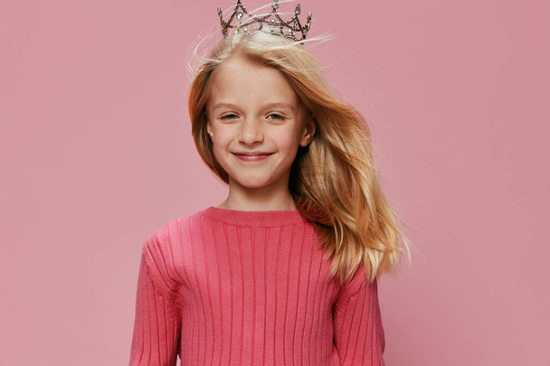 Aranyos kislány egy rózsaszín hercegnő korona ünnepli születésnapját egy vidám és varázslatos karnevál party - Fotó, kép