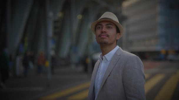 Divatos fiatal jóképű férfi kalapban és alkalmi ruhában a városban - Felvétel, videó